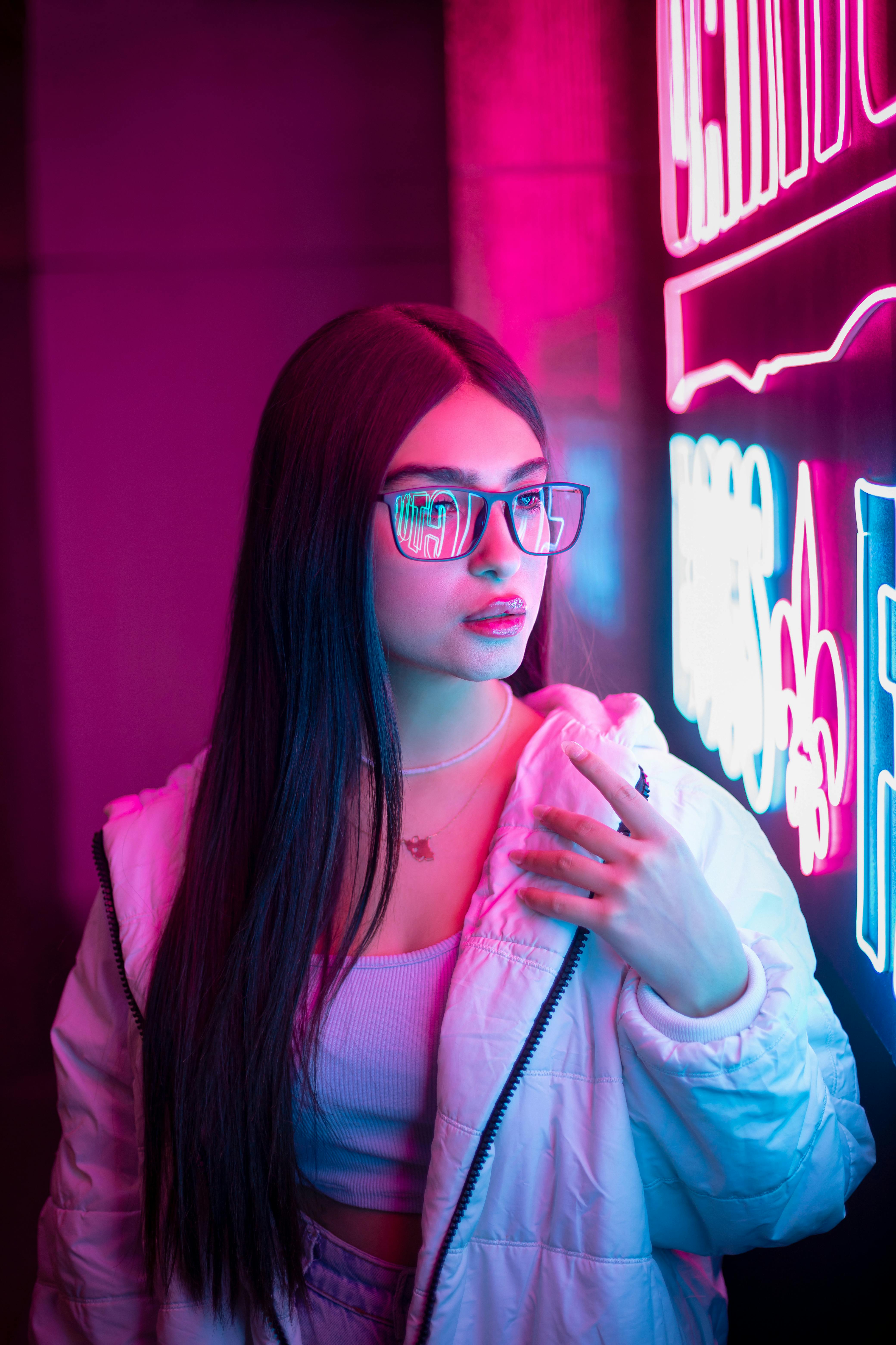 Woman practicing a breathing technique illuminated by pink neon light
